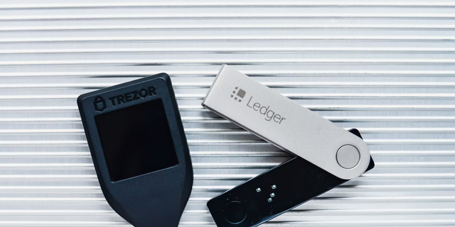 trezor-and-ledger-hardware-wallets-on-a-white-metal-background